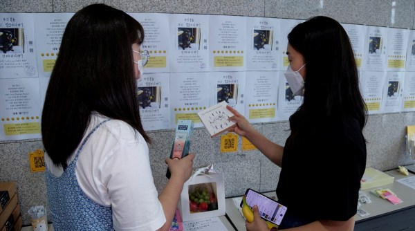 Women take a look at items at a faeces currency market