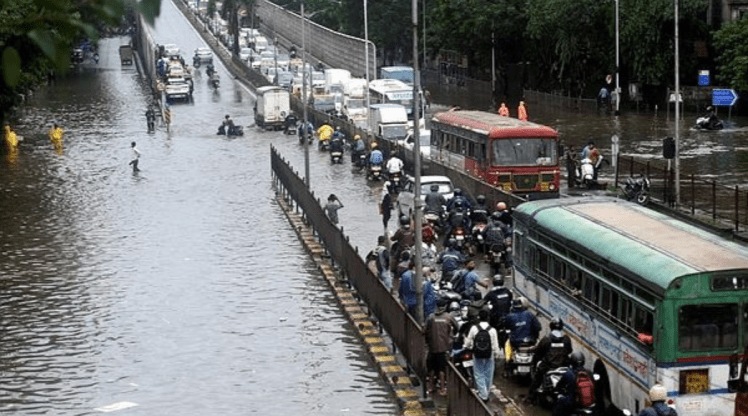 Vehicles make their way through the waterlogged streets at Kings Circle in Mumbai. (PTI)