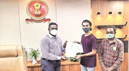 Rajkot collector Arun Mahesh Babu hands over the certificate to Chirag alias Charmi Makwana. (Express)