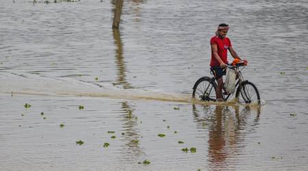 A cyclist wades through a flooded street after heavy rain in Bishalghar village on the outskirts of Agartala, Thursday, July 1, 2021. (PTI Photo)