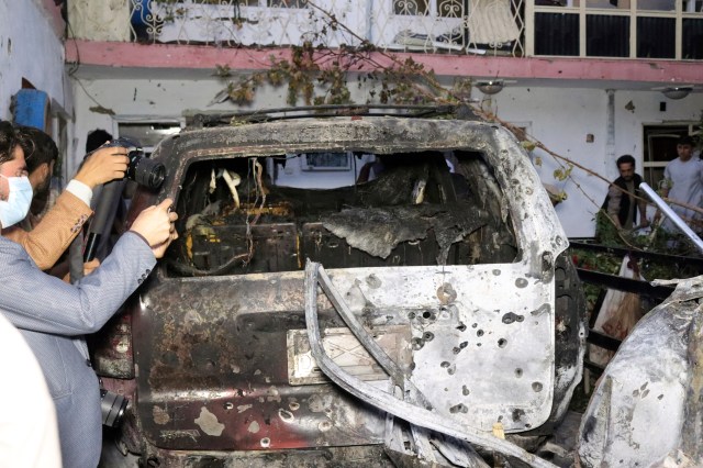 Afghan journalists take a photos of destroyed vehicle inside a house after U.S. drone strike in Kabul, Afghanistan, Sunday, Aug. 29, 2021. (AP Photo/Khwaja Tawfiq Sediqi)