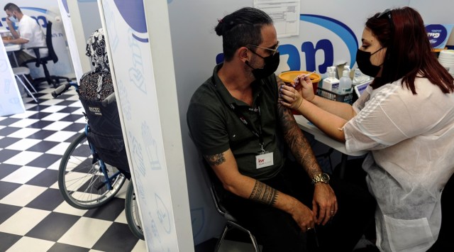 Israeli man receives a third shot of Covid-19 vaccine as country launches booster shots for over 30-year-olds, in Rishon Lezion, Israel August 24, 2021. (Reuters)