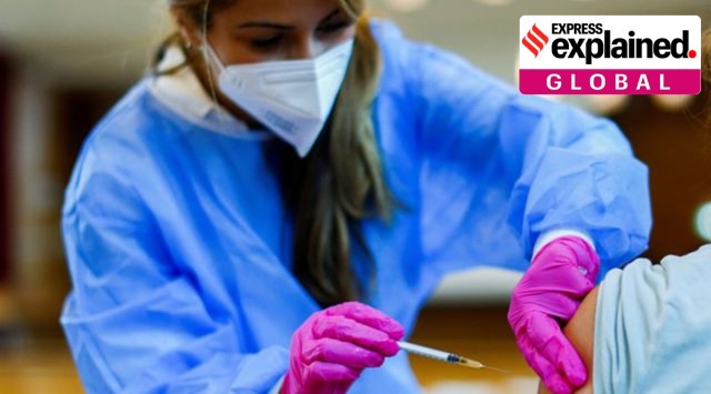 A medical worker in a school hall administers a dose of the Pfizer-BioNTech COVID-19 vaccine to a student of the Leibniz-Montessori secondary school, amid the coronavirus disease (COVID-19) pandemic, in Dusseldorf, Germany, August 27, 2021. REUTERS/Thilo Schmuelgen/File Photo