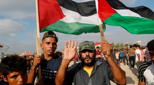 Protestors wave their national flags near the fence of Gaza Strip border with Israel, during a protest marking the anniversary of a 1969 arson attack at Jerusalem's Al-Aqsa mosque by an Australian tourist later found to be mentally ill,  east of Gaza City, Saturday, Aug. 21, 2021. (AP Photo/Adel Hana)