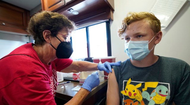 Nurse Carole Weaver, left, gives a Covid-19 vaccination shot to thirteen-year-old Jesse James, of Pleasantville, Iowa. (AP)