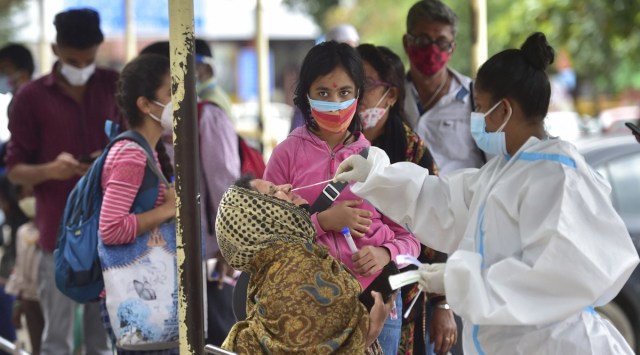 A health worker collects samples of passengers for Covid-19 test at city railway station in Bengaluru. (Photo: PTI)
