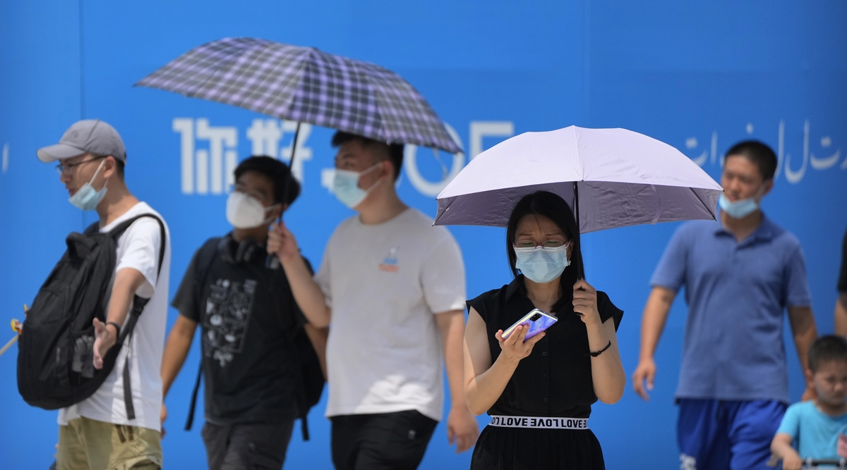 Visitors wear face masks to protect against Covid-19 as they walk at a tourist shopping street in Beijing, Tuesday, Aug. 3, 2021. (AP)