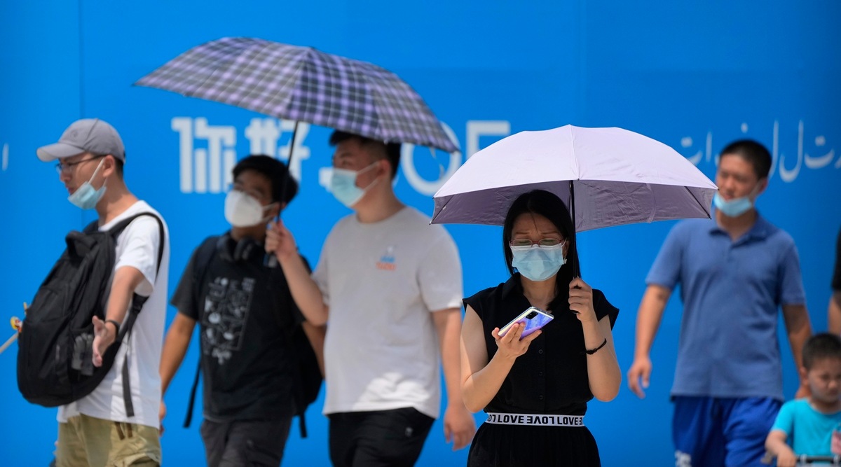 Visitors wear face masks to protect against Covid-19 as they walk at a tourist shopping street in Beijing, Tuesday, Aug. 3, 2021. (AP)