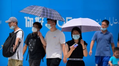 Visitors wear face masks to protect against Covid-19 as they walk at a tourist shopping street in Beijing, Tuesday, Aug. 3, 2021. (AP)