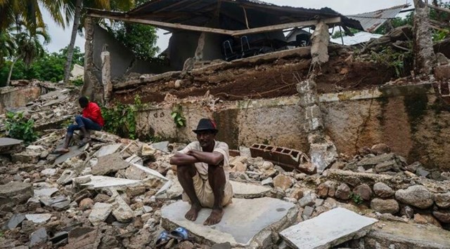 A man crouches on the rubble of the hospital destroyed by the earthquake in Fleurant, Haiti, three days after the 7.2-magnitude quake hit the Caribbean nation. (Photo: AP)