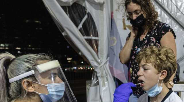 A medical professional takes samples from a child for a coronavirus test in Rabin Square in the city of Tel Aviv, Israel, Saturday, Aug. 14, 2021. (AP Photo/Tsafrir Abayov)