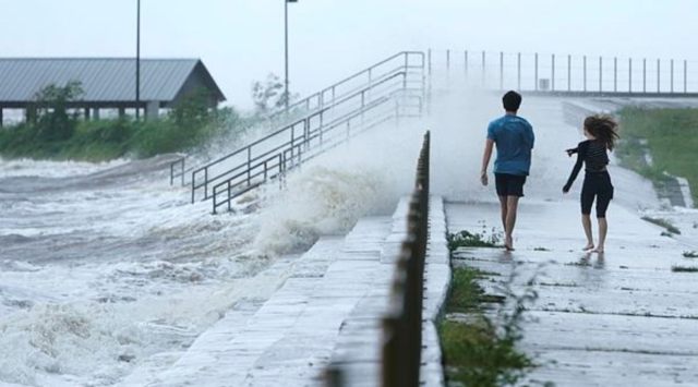 Local residents Portia Potyok, right, and Bradley Darby, watch the wind and waves along a seawall as outer bands of Hurricane Ida arrive Sunday, Aug. 29, 2021, in Bay Saint Louis, Miss. (AP)