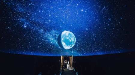 A photo provided by JD Land, Salt & Sonder Studio, shows Amanda Gefter and Justin Smith getting married under a giant moon in Philadelphia’s Franklin Institute planetarium in July 2017. (JD Land, Salt & Sonder Studio via The New York Times) 