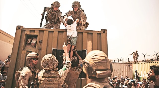 US Marines, coalition forces assist a child during evacuation at Kabul airport on Friday. (AP)