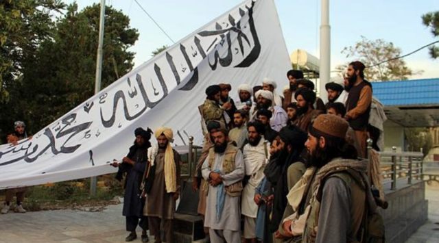 Taliban fighters poses for a photograph while raising their flag Taliban fighters raise their flag at the Ghazni provincial governor's house, in Ghazni, southeastern, Afghanistan, Sunday, Aug. 15, 2021. (AP/PTI)