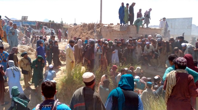 Taliban fighters and Afghans gather around the body of a member of the security forces who was killed, inside the city of Farah, capital of Farah province, southwest Afghanistan, Wednesday, Aug. 11, 2021. (AP)