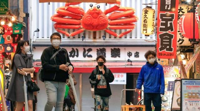 People wearing a face mask walk through downtown Osaka, western Japan, Friday, May 7, 2021. (Yukie Nishizawa/Kyodo News via AP)