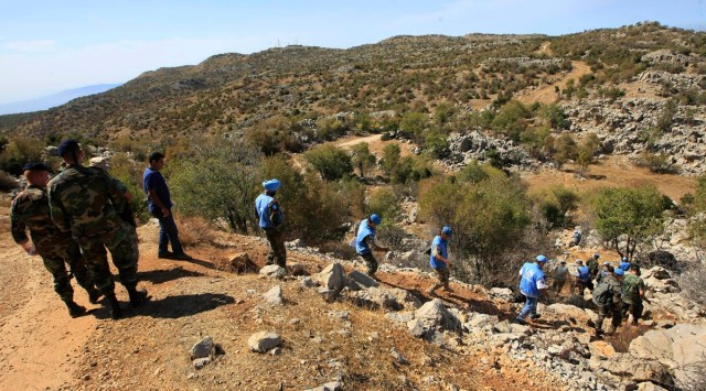 FILE - In this Oct. 8, 2014, file photo, Lebanese army soldiers and U.N. peacekeepers investigate near the site where Hezbollah had attacked on an Israeli patrol, in the hills of Kfar Shouba village, near the Israeli-occupied Shebaa farms, southern Lebanon. (AP Photo/Mohammed Zaatari, File)