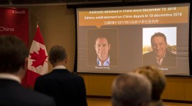 A video screen displays images of Canadians Michael Kovrig, left, and Michael Spavor at an event held in connection with the announcement of the sentence for Spavor at the Canadian Embassy in Beijing.