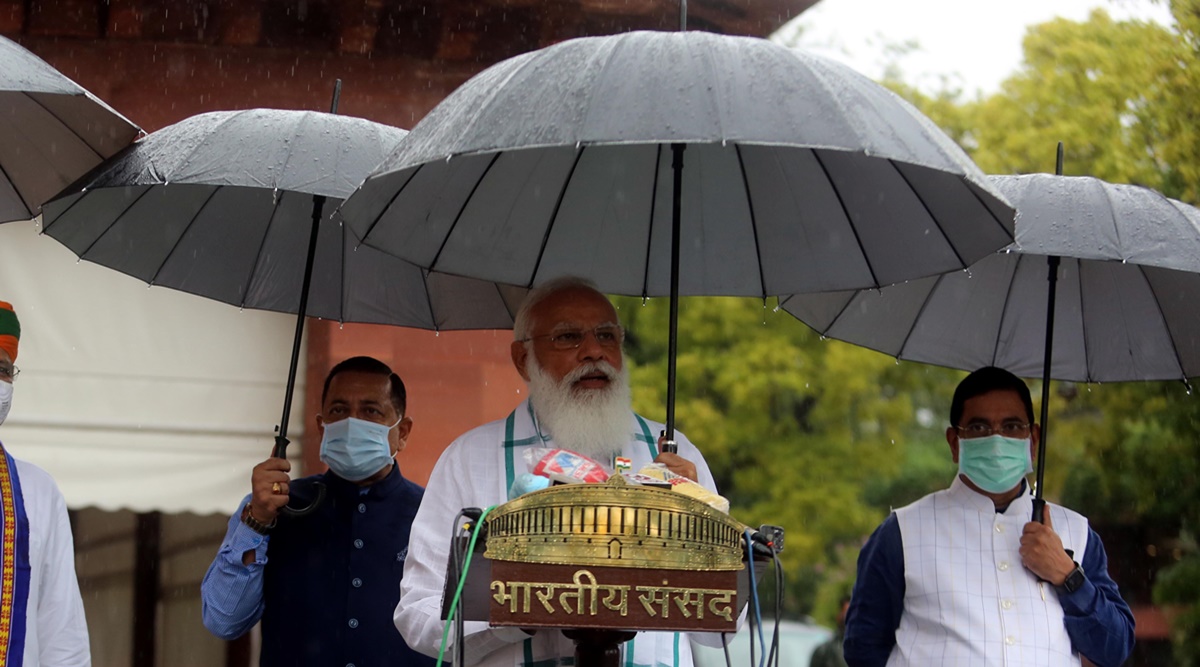 New Delhi, India. 19th July, 2021. Prime Minister Narendra Modi holds an  umbrella to protect from the rain as he addresses the media on the opening  day of the monsoon session of