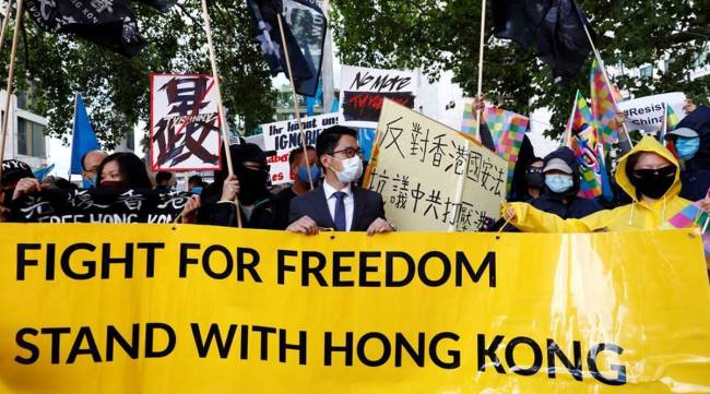 Hong Kong exile pro-democracy activist Nathan Law wearing a face mask holds a rally with other activist groups during China's Foreign Minister Wang Yi's visit in Berlin. (Photo: Reuters/File)