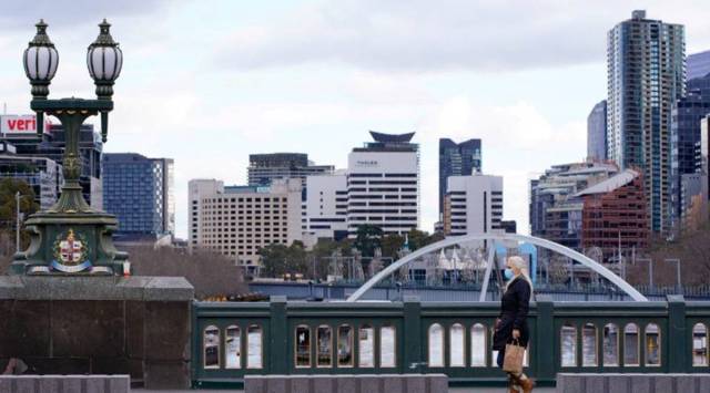 A lone woman, wearing a protective face mask, walks across an unusually quiet city centre bridge as the state of Victoria looks to curb the spread of coronavirus outbreak in Melbourne, Australia, July 16, 2021. (Reuters/File)
