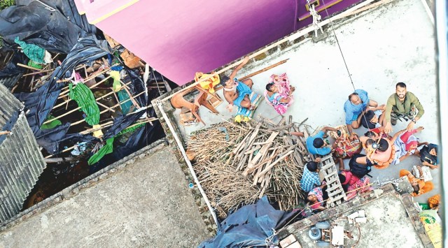 People stranded on the roof of their house in a flood-affected area of Khanakul in Hooghly district. (Photo: PTI)