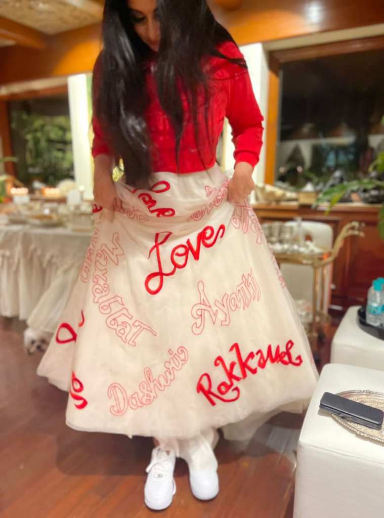 Rhea Kapoor luce el look de novia moderno con una combinación de chaqueta bomber roja y falda de organza