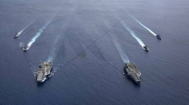 In this file photo, US Carrier Strike Groups steam in formation in the South China Sea. (Mass Communication Specialist 3rd Class Jason Tarleton/US Navy via AP)