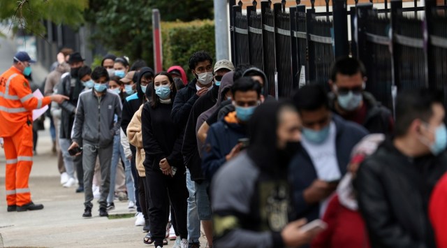 People wait in line outside a coronavirus disease vaccination clinic in the Bankstown suburb during a lockdown to curb an outbreak of cases in Sydney. (Reuters)