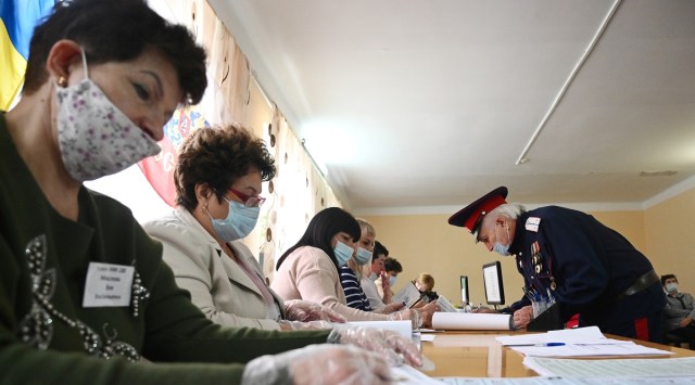 A Cossack receives his ballots at a polling station on the last day of three-day long parliamentary elections in the settlement of Krasny Kolos in Rostov Region. (Reuters)