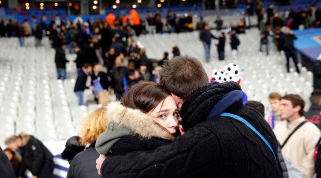 In a 2015 photo, a supporter comforts a friend following attacks outside the Stade de France stadium. Nine gunmen and suicide bombers struck within minutes of each other at the national soccer stadium, the Bataclan concert hall and restaurants and cafes. (AP)