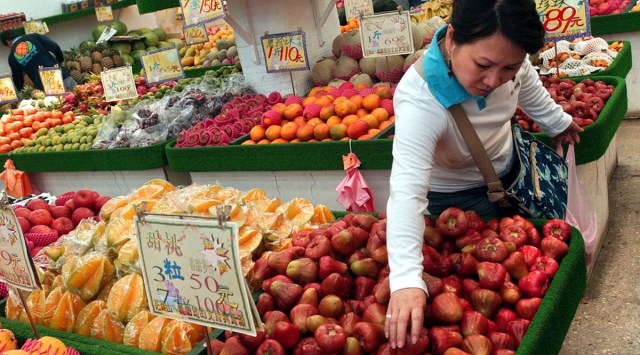 In this file photo taken Friday, April 15, 2005, a woman picks "lien wu" or wax apple, a Taiwanese tropical fruit, at a local fruit market in Taipei, Taiwan. (AP)