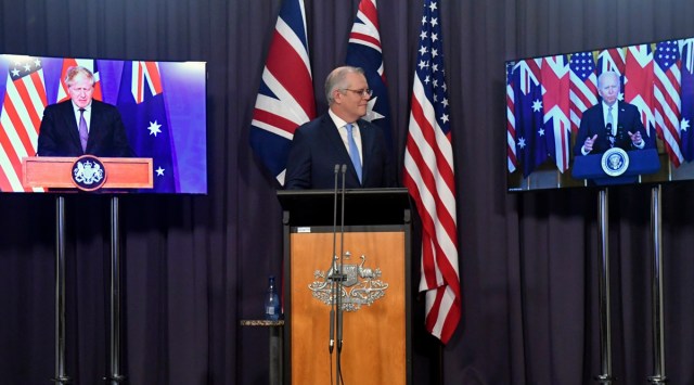 Australia's PM Scott Morrison on stage with video links to Britain's PM Boris Johnson and US President Joe Biden at a press conference in Canberra, Thursday, Sept. 16, 2021. (Mick Tsikas/AAP Image via AP)