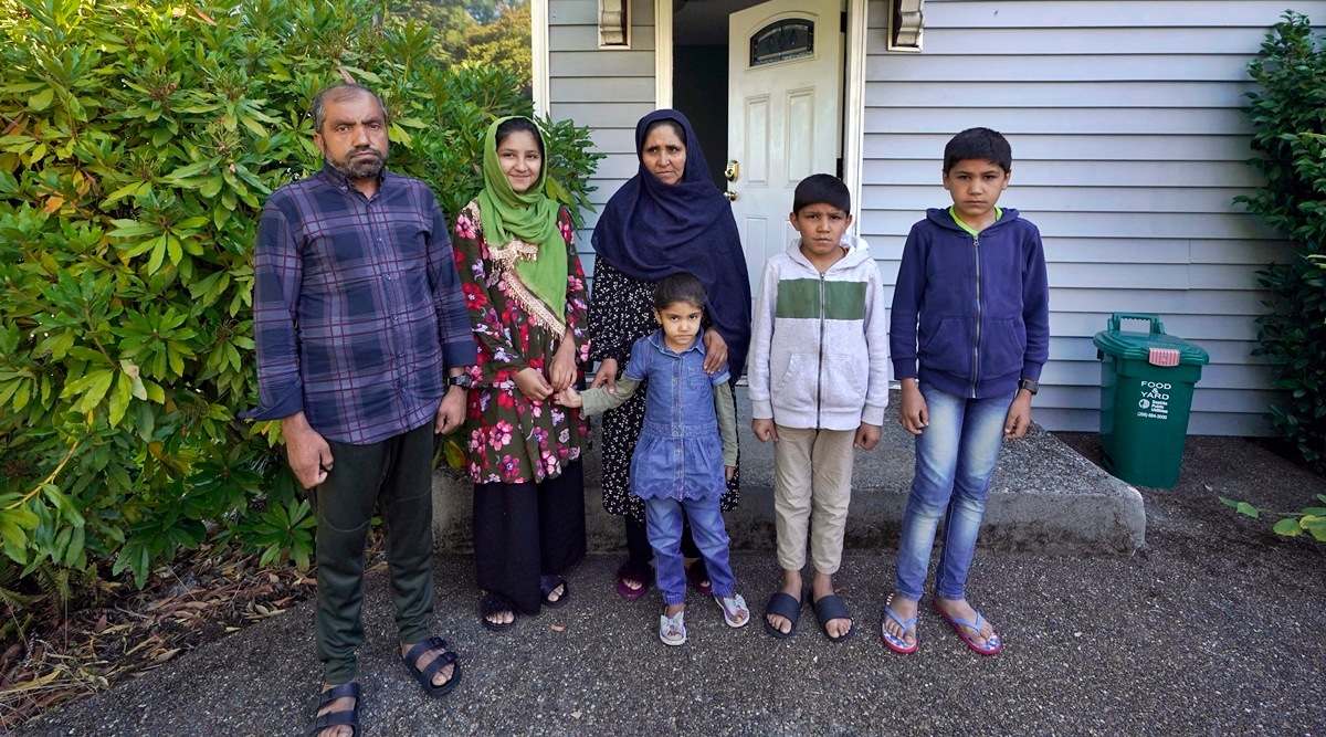 Abdul, left, who worked as a mechanic before he left Kabul, Afghanistan with his family about a month ago, poses for a photo, Thursday, Sept. 16, 2021, with his family in front of a rental house where they have been provided a place to stay in Seattle. (AP)