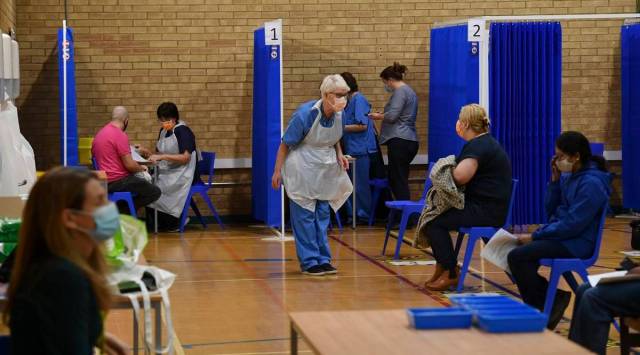 A member of staff collects the next patient to receive the Pfizer-BioNTech Covid-19 vaccine at a vaccination centre in Cardiff, Wales. (AP)
