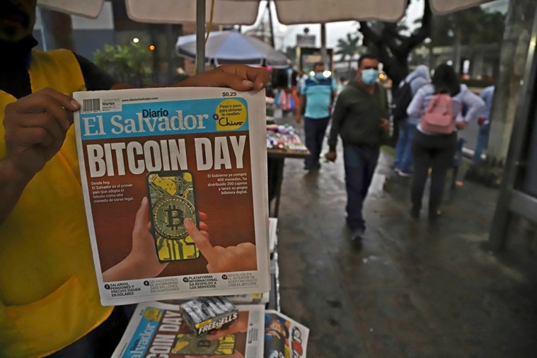 A newspaper vendor shows the front page of a state-run newspaper carrying the headline "Bitcoin Day" in San Salvador, El Salvador, Tuesday, Sept. 7, 2021. (AP Photo/Salvador Melendez)