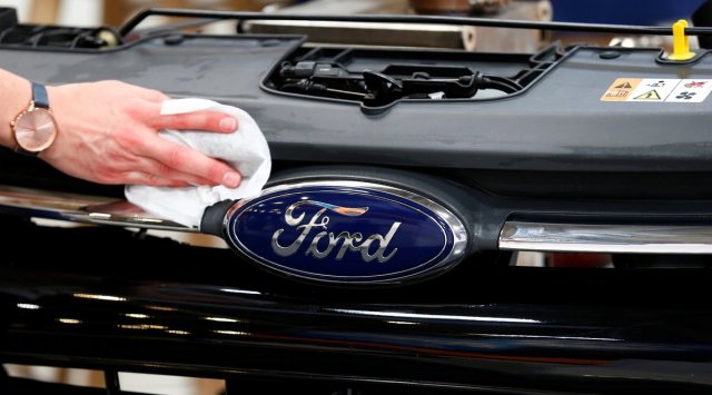 A worker cleans a part of the front of a Ford ahead of the Munich Motor Show IAA Mobility 2021 in Munich, Germany, September 6, 2021. (REUTERS)