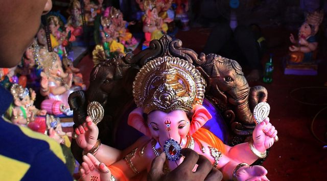 An artist gives finishing touches to the ganpati idol before sales. 
(Express Photo by Amit Chakravarty)