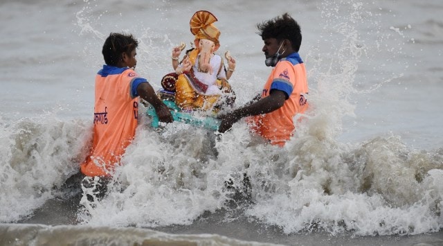 Volunteers immerse an idol of Lord Ganesha at Girgaon Chowpattyin in Mumbai on Thursday. (Photo: PTI)