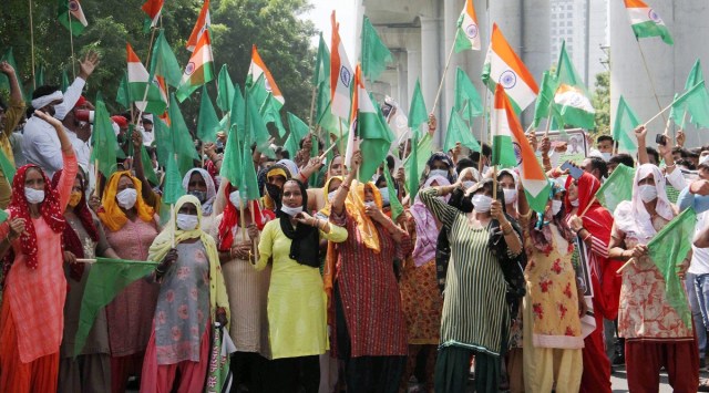 File image of women farmers holding national flags during their protest outside Greater Noida Development Authority. (PTI Photo)