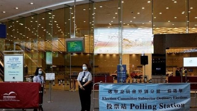 Security guards stand outside a polling station during voting of the election committee, in Hong Kong, China, September 19, 2021. (Reuters)