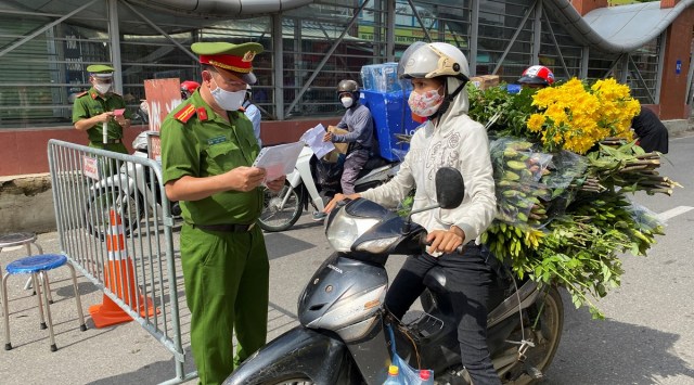 Vietnam police officers inspect authorised travel documents of commuters at a check point during the first day of the extended lockdown in Hanoi, Vietnam, September 6, 2021. (Reuters)