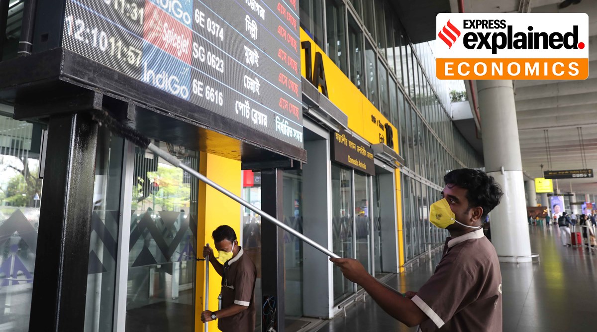 Workers sanitize flight information boards at Netaji Subash Chandra International Airport in Kolkata. (Express Photo: Partha Paul, File)