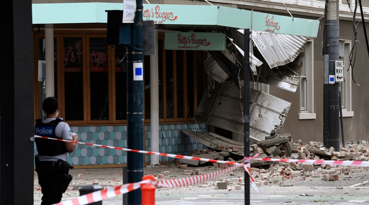 A police officer closes an intersection where debris is scattered in the road after an earthquake damaged a building in Melbourne on Sept. 22, 2021. (AP)