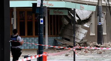 A police officer closes an intersection where debris is scattered in the road after an earthquake damaged a building in Melbourne on Sept. 22, 2021. (AP)