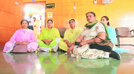 Councillor sit on the floor in protest outside the Mayor’s office after MC meeting in Mohali on Tuesday.  Photo: Jasbir Malhi