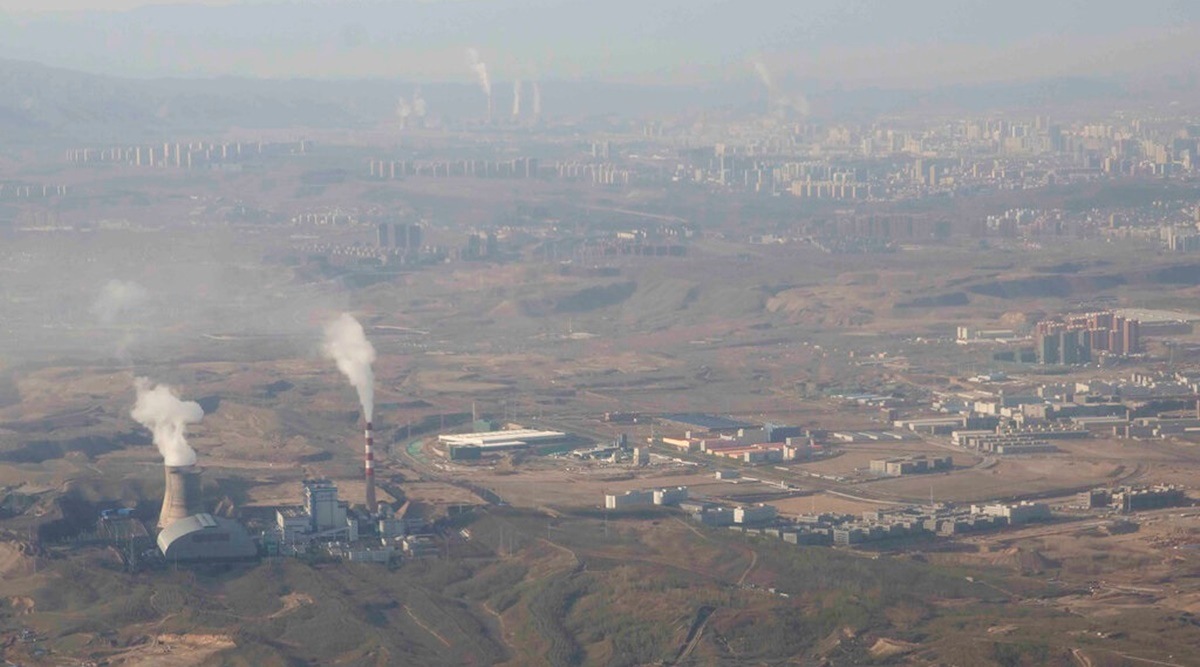 In this April 21, 2021, file photo, smoke and steam rise from towers at the coal-fired Urumqi Thermal Power Plant as seen from a plane in Urumqi in western China's Xinjiang Uyghur Autonomous Region. (AP Photo)
