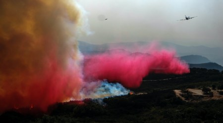 An air tanker drops retardant on a wildfire Wednesday, Oct. 13, 2021, in Goleta, Calif. (AP Photo/Ringo H.W. Chiu)