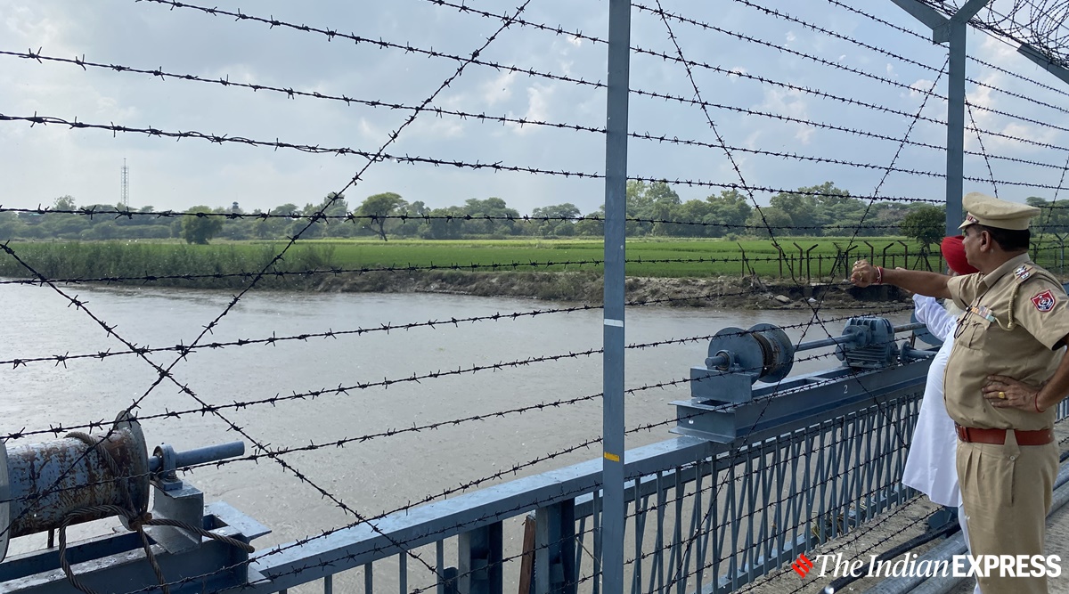 SHO Khemkaran pointing towards a Pakistan Rangers post near the Kasur Nullah. (Express photo/Man Aman Singh Chhina)